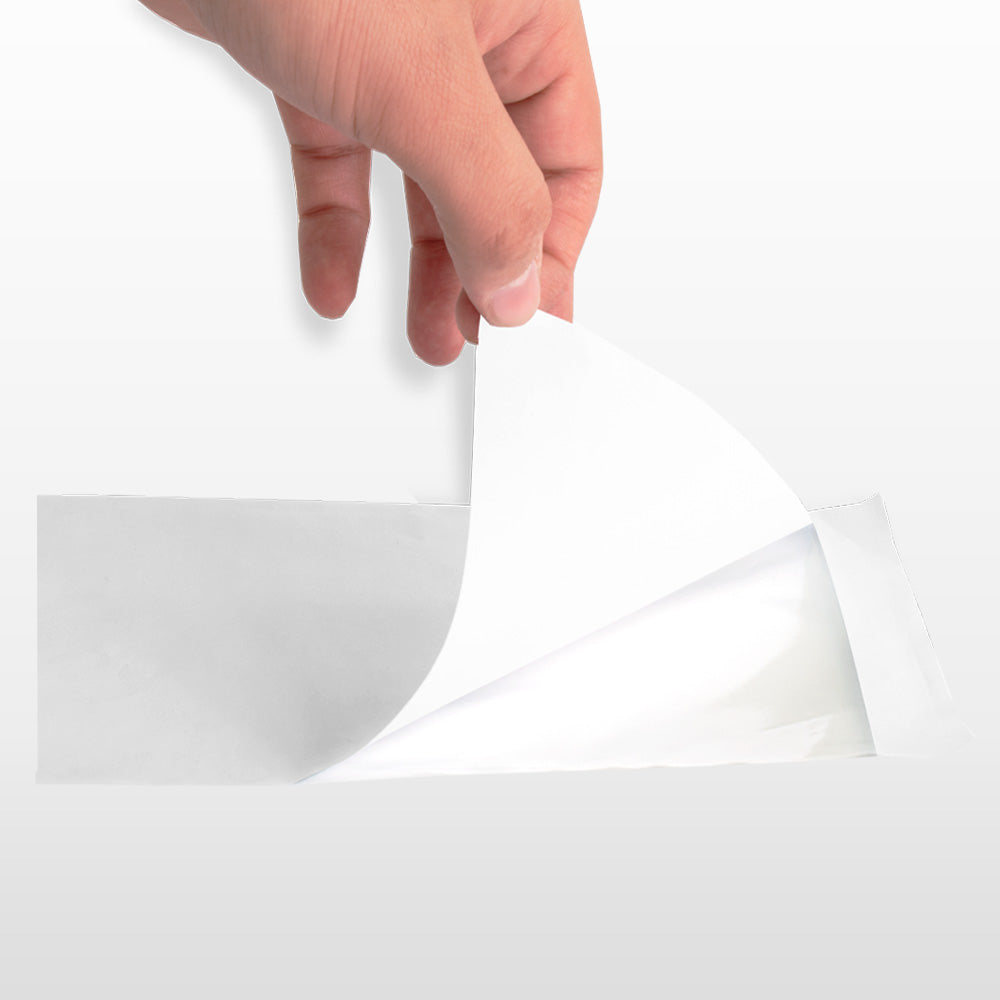 Mano retirando el papel protector de un sobre autoadhesivo.