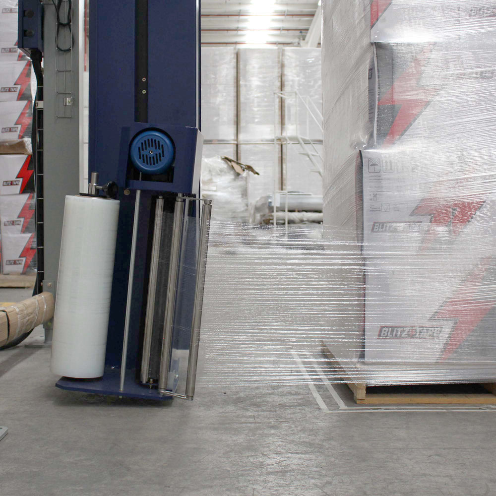 Película stretch automática transparente instalada junto a una tarima de cajas envueltas.