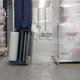 Película stretch automática transparente instalada junto a una tarima de cajas envueltas.